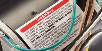 A WARNING label on an appliance motor
