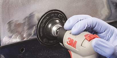 sanding a damaged area to prepare for filler
