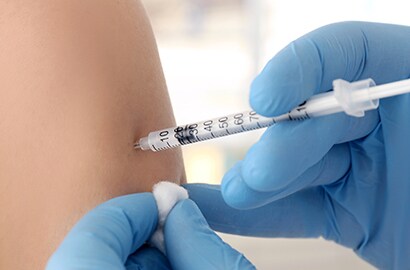 Healthcare worker administers vaccine into arm