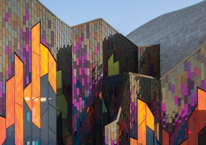 Exterior shot of building with angular window panels of covered with warm toned 3M Dichroic glass finish.