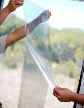 hands applying window films to a window
