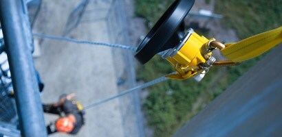 Worker suspended from controlled descent device
