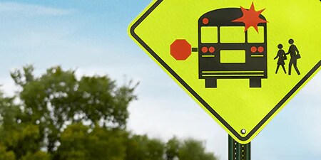 A yellow sign with a bus on it
