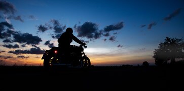 A person on a motorcycle at sunset

