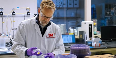 Man in lab looking down at equipment
