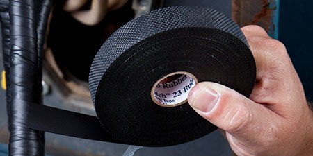 worker wrapping cable with 3M Rubber Electrical Tape
