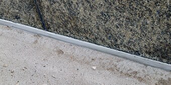 Sealed expansion joint between different materials that may expand and contract at different
