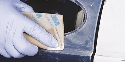 hand sanding edges of repair area
