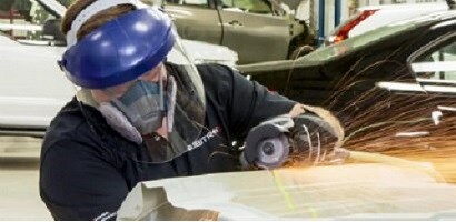 A person using a grinder to cut a piece of metal
