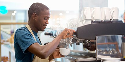 A barista making a cup of coffee.
