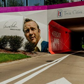 A tunnel with a large graphic of legendary golfer Arnold Palmer near the opening.