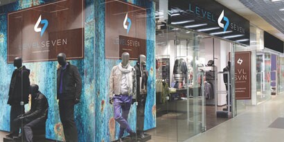 A shopping mall hallway features a wall wrap and overlaminate with images of models.

