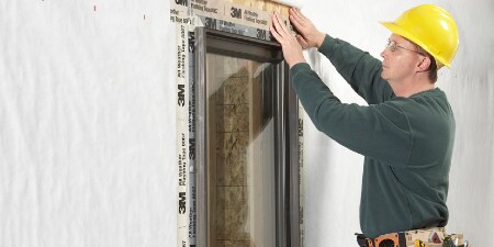 Construction worker flashing a window with 3M tape

