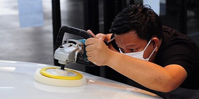 A person using a machine to polish a car
