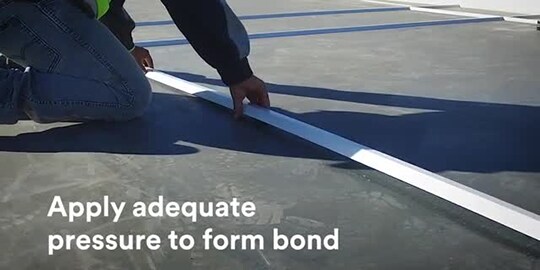 Construction worker laying down reveals with screen text “Apply adequate pressure to form bond”​
