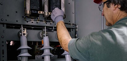 A man monitors electrical components to keep the grid working reliably and efficiently.
