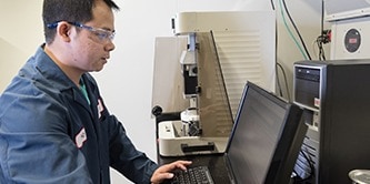 Person on a computer with protective glasses on indicating interconnect expertise
