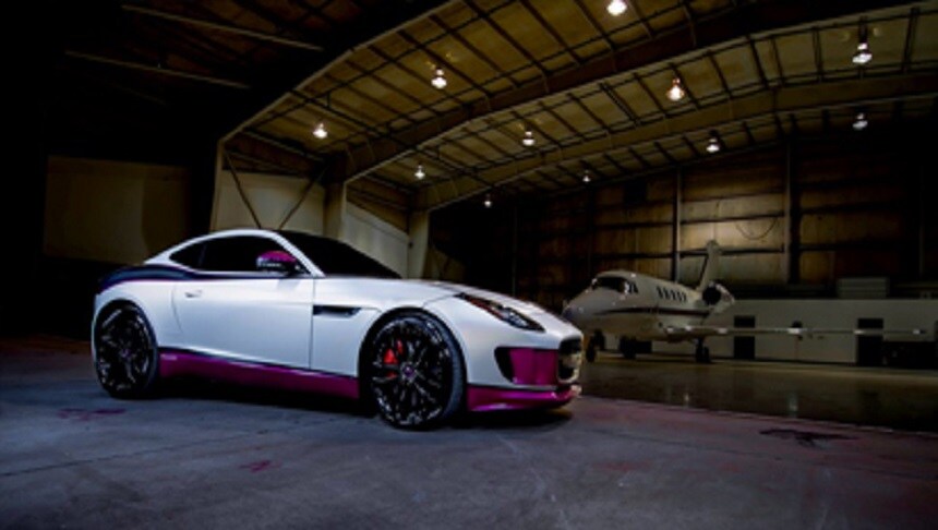 white and pink car in a hangar
