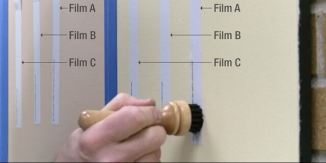 Person holding wooden eraser on white board covered in 3M textured wall film
