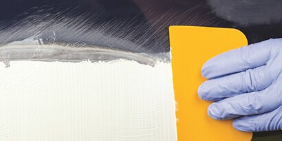 applying filler to aluminum panel
