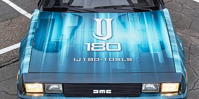 A close up of a blue and white truck hood wrapped in 3M IJ180-10SLS print wrap film, with a white IJ180 logo on the hood.
