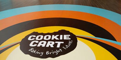 A floor graphic displays a colorful, circular branding design for 