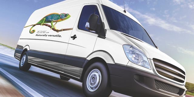 A white van driving on a highway with a chameleon on the side of it using the 3M 48C graphic film.