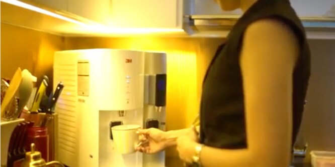 Woman using 3M's water dispenser
