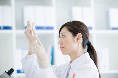 A person in a lab coat holding a test tube
