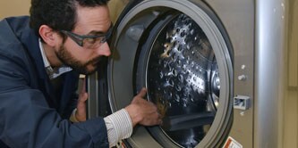 A man assembles a washing machine door
