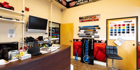 Dated, cluttered office with posters on pale yellow walls.
