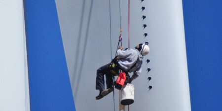 worker applying vortex generators to wind blade
