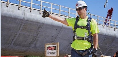 Worker in fall protection gear at construction site
