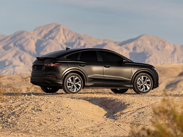 Black sedan with matte car ppf parked offroad with mountains in the background