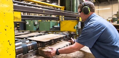 A person wearing headphones and working on a machine
