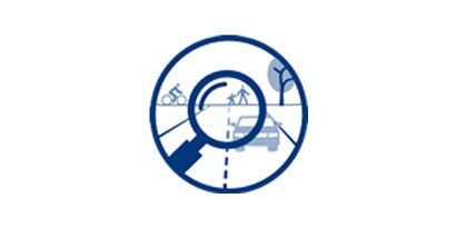 Blue and white line drawing of magnifying glass over road with car, pedestrians and bicyclist.
