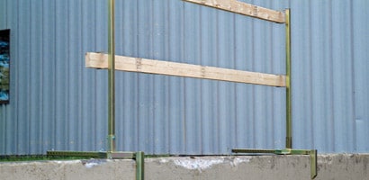 Temporary wooden guardrail attached to concrete walkway
