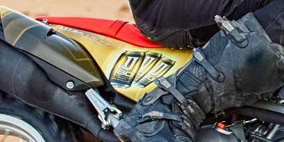  A close up of a motorcycle seat wrapped in an orange and yellow 3M IJ180C-10LLSE print wrap film.
