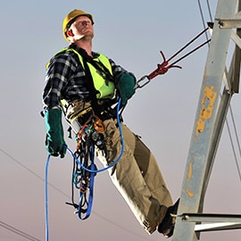 man ascending electrical tower