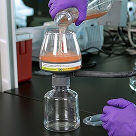 Photo of technician pouring fluid into the bottle top configuration