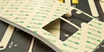 Image of a sheet of double sided tape with two square die-cuts removed
