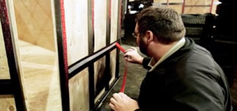 A man applying 3M VHB tape onto a wooden panel