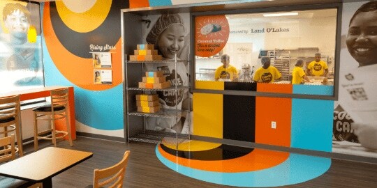A restaurant has colorful wall and floor graphics and large-scale black and white wall photos
