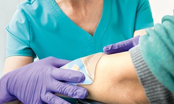 Clinician applying a Tegaderm Dressing
