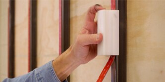 Worker applies 3M™ VHB™ Tape on bar with 3M™ Hand Tape Applicator.
