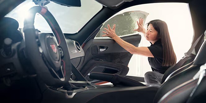 Auto film specialist applying 3M car film to a vehicle window.
