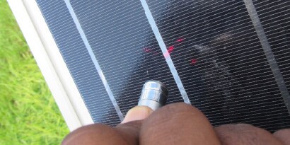 Photo of man shining laser on solar panel to show dispersion

