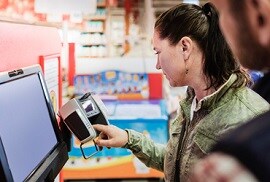 woman checking out at a register in a local store