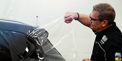 Installer removes the Protective Film Layer of 3M Wrap Film Series 2080 from the back of a car.

