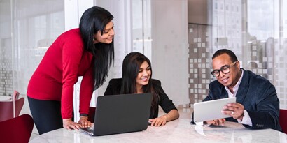 Employees collaborating over laptop and tablet